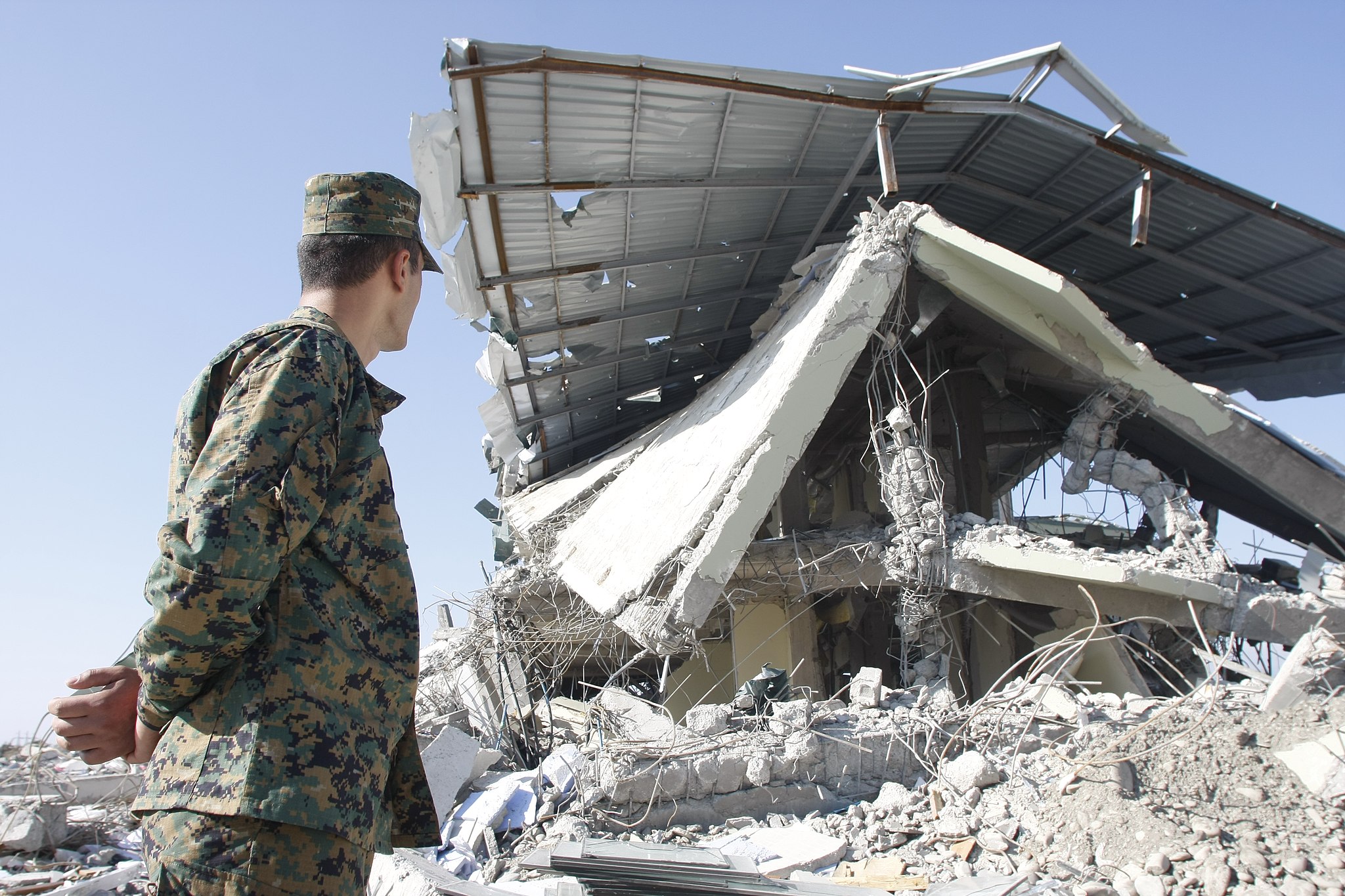 Grúz katona tekinti meg az összeomlott épületet